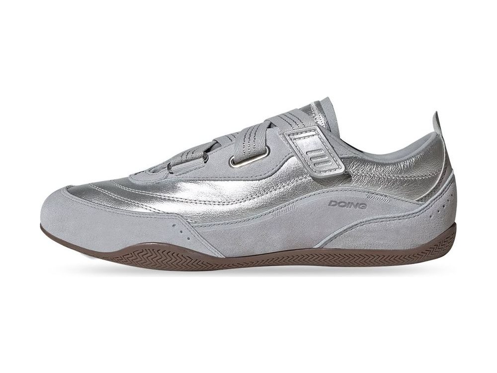 OEM/ODM metallic silver leather trainer with a hook-and-loop instep strap over the laces, grey suede quarter and heel panels and a gum herringbone outsole, manufactured by DOING Footwear