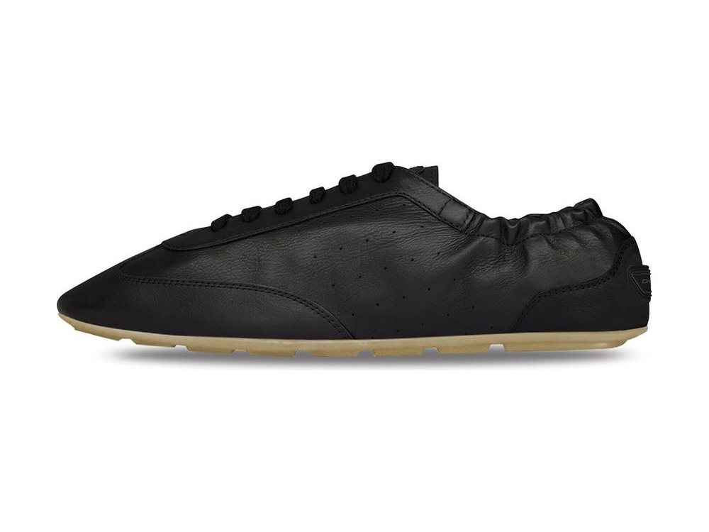 OEM/ODM black leather flat sneaker with an elongated pointed toe, gathered elastic collar, perforated side panel, corded lace loops and a slim translucent gum outsole, manufactured by DOING Footwear